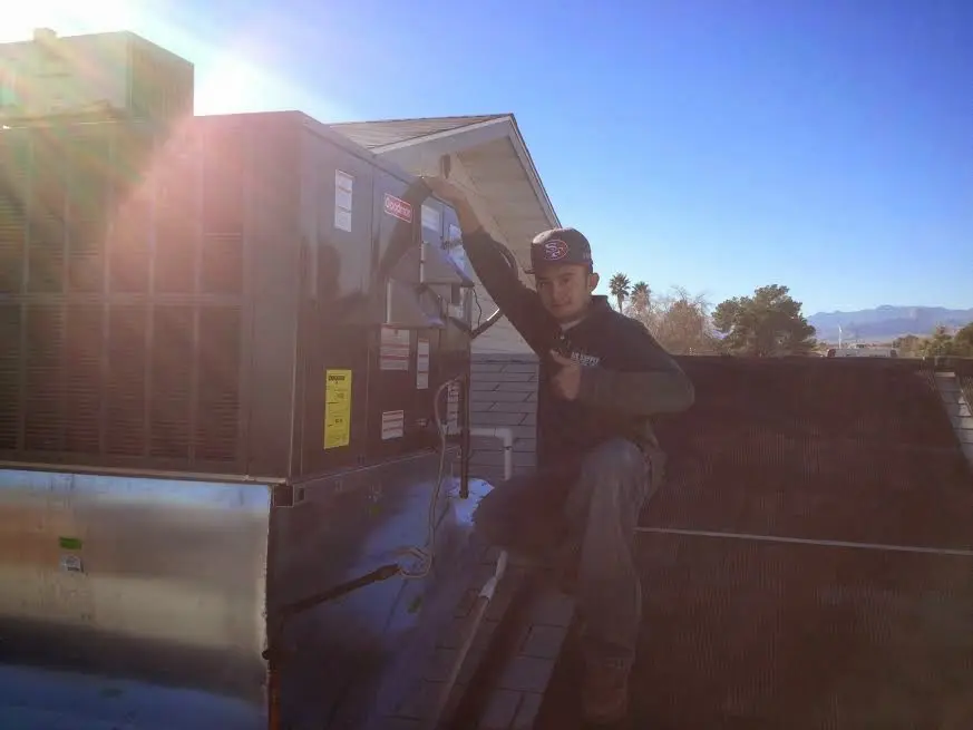HVAC technician performing AC Tune-Up on a rooftop unit in Western Springs